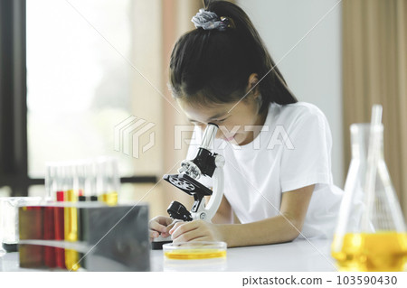 Little child with learning class in school laboratory using microscope 103590430