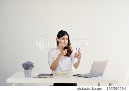 A happy Asian businesswoman is talking with her friends through a video call 103590664