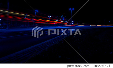 Lights of cars at night. Street line lights. Night highway city. Long exposure photograph night road. Colored bands of red light trails on the road. Background wallpaper defocused Lights of cars at night. Street line lights. Night highway city. Long exposure photograph night road. Colored bands of red light trails on the road. Background wallpaper defocused 103591471
