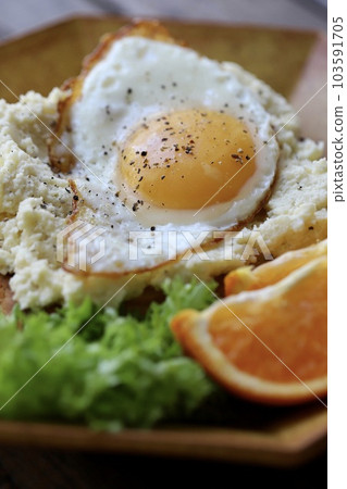 Potato salad and fried egg open sandwich topped with bread 103591705