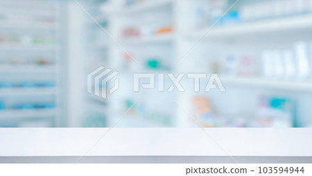 Empty white counter with pharmacy drugstore shelves blurred background Empty white counter with pharmacy drugstore shelves blurred background 103594944