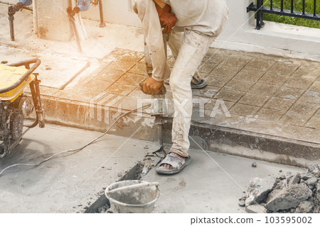 Construction worker using jackhammer drilling concrete surface 103595002