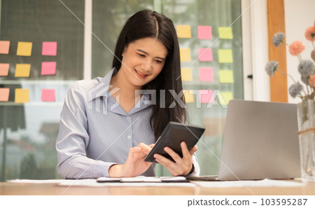 Asian businesswoman sit at their desks and calculate financial graphs showing results about their investments, plan a successful business growth process Asian businesswoman sit at their desks and calculate financial graphs showing results about their investments, plan a successful business growth process 103595287