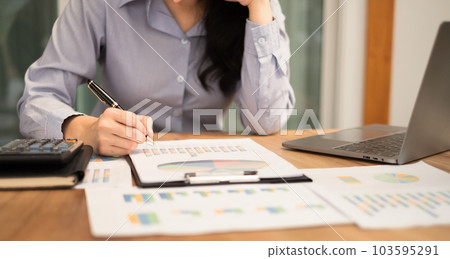 Asian businesswoman sit at their desks and calculate financial graphs showing results about their investments, plan a successful business growth process Asian businesswoman sit at their desks and calculate financial graphs showing results about their investments, plan a successful business growth process 103595291
