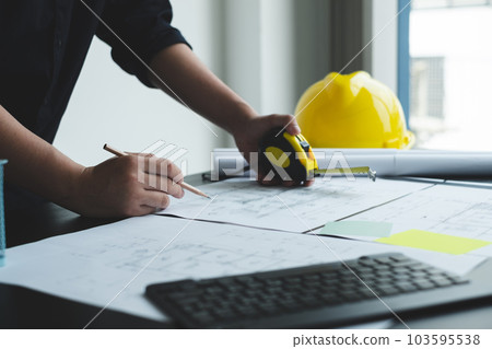 Architects or engineers working construction and drawing construction plans, printing, writing on-site construction sites. Home design concept 103595538
