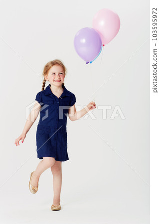 Smile, balloons and girl playing in studio isolated on a white background mockup space. Happiness, air balloon and kid play games with inflatable toys, having fun and enjoying birthday celebration. Smile, balloons and girl playing in studio isolated on a white background mockup space. Happiness, air balloon and kid play games with inflatable toys, having fun and enjoying birthday celebration. 103595972