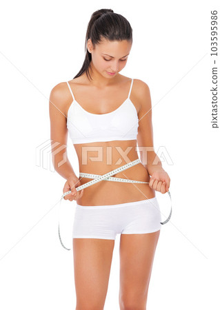 Woman, fitness and tape measure for lose weight, diet or waist against a white studio background. Fit or slim female model in underwear or lingerie measuring healthy body or figure for wellness 103595986
