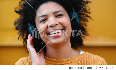 Black woman, portrait or music headphones on isolated yellow background, fashion mockup or wall mock up. Smile, happy or laughing student listening to radio, audio and podcast in trendy or cool cloth 103595992