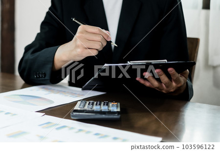 The businessman hand sits at their desks and calculates financial graphs showing the results of their investments planning the process of successful business growth 103596122