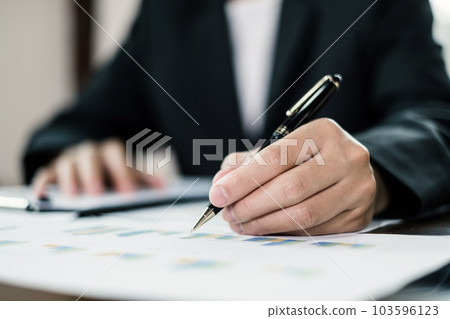 The businessman hand sits at their desks and calculates financial graphs showing the results of their investments planning the process of successful business growth The businessman hand sits at their desks and calculates financial graphs showing the results of their investments planning the process of successful business growth 103596123