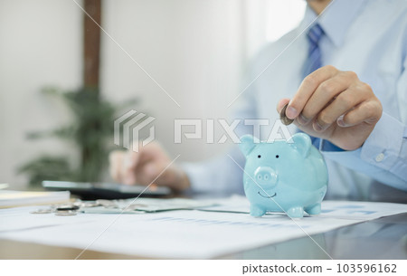 Man putting coin into piggy bank. Saving money with coins Step into a business that is growing to be successful and save for retirement concepts Man putting coin into piggy bank. Saving money with coins Step into a business that is growing to be successful and save for retirement concepts 103596162