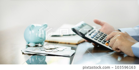 Man hand count coins, store piggy bank, and using a calculator Calculate graphs to build successful and economical businesses for retirement concepts 103596163