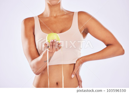 Apple, health and tape measure for diet of woman in studio for healthy lifestyle, weight loss or fitness. Female on a white background for wellness and fruit motivation in hand for healthcare goals 103596330