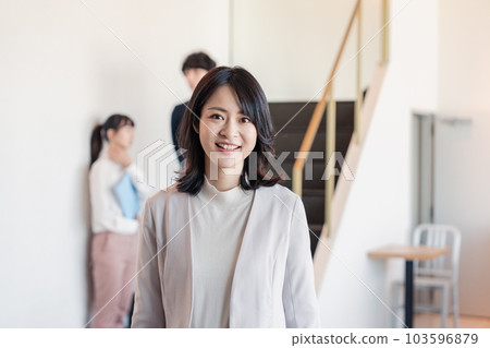 Female manager walking in the office with a smile 103596879