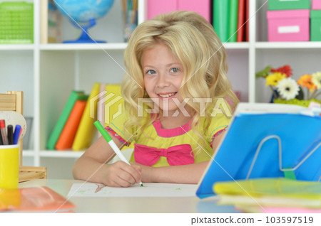 little girl studying at home at the table little girl studying at home at the table 103597519