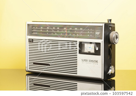 Old transistor radio on a yellow background Old transistor radio on a yellow background 103597542