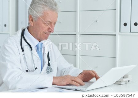 portrait of confident old nice doctor with stethoscope working in office 103597547