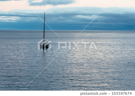 Idyllic image of a sailing yacht anchored in the harbor of Angra do Heroismo harbor at dusk. 103597674