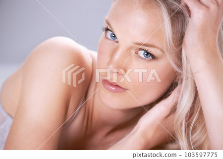 Sensual, beauty and portrait of a woman on a bed with a self care, natural and body care routine. Cosmetic, makeup and face of beautiful, young and attractive female model with elegant seductive pose 103597775