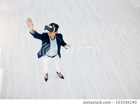What does the future of business look like to you. High angle shot of a young businesswoman wearing a VR headset in an office. 103598140