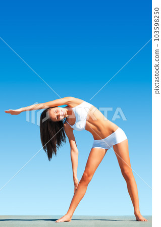Woman, yoga and stretching body for workout, exercise or fitness standing on floor against blue sky. Calm and peaceful female yogi in warm up arm stretch for healthy balance outdoors on mockup space 103598250