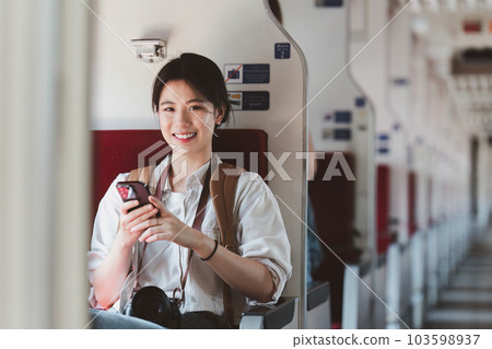 Asian Tourist person backpacker to travel at train station and using mobile phone. Tourism and travel in the summer 103598937