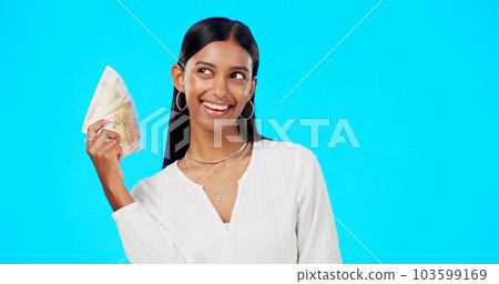 Rich, happy and face of a woman with money isolated on a blue background in a studio. Smile, wealth and a portrait of a girl fanning with cash, lottery jackpot and dollars from a bonus on a backdrop 103599169