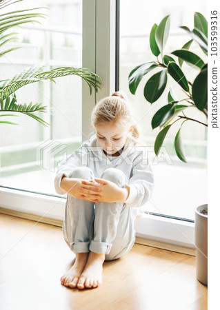 Lonely sad girl near the window. Lonely sad girl near the window. 103599316