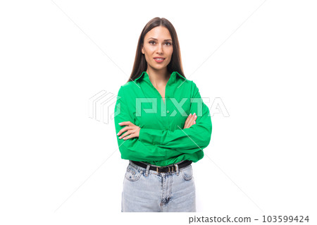 pretty young caucasian brunette lady with makeup dressed in a green shirt and jeans posing on a 103599424
