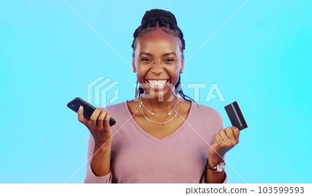 Black woman, credit card and smartphone for online shopping, retail and payment with lady against a blue studio background. Nigerian female customer, client and shopper with cellphone and ecommerce 103599593