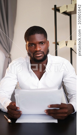 Professional leadership. Office paperwork. Confidence expertise. Young business man CEO discussing documents in hands at table in modern interior. 103601642
