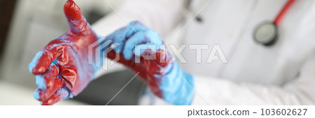 Closeup of hands of surgeon in blood after operation Closeup of hands of surgeon in blood after operation 103602627
