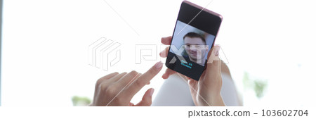 Young woman looking through profiles of men on dating app on mobile phone Young woman looking through profiles of men on dating app on mobile phone 103602704