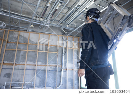 一名工人在建築工地用梯子行走 103603404