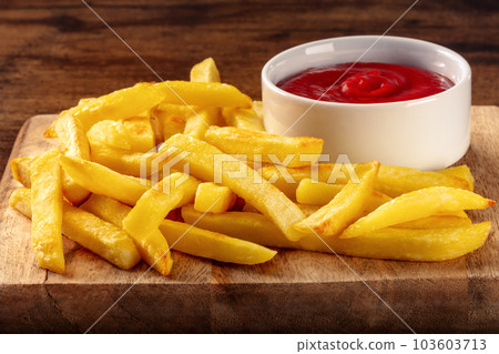French fries, potato snack with ketchup, fast food on a wooden table 103603713