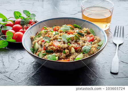 Quinoa tabbouleh salad in a bowl, a healthy dinner with tomatoes and mint Quinoa tabbouleh salad in a bowl, a healthy dinner with tomatoes and mint 103603724