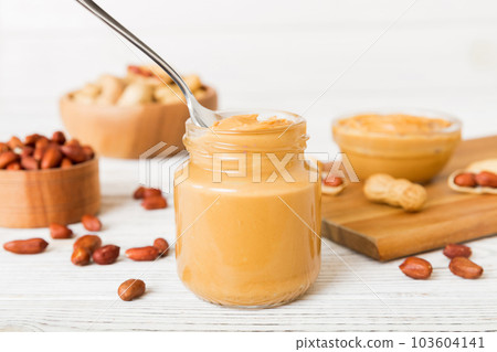 Bowl of peanut butter and peanuts on table background. top view with copy space. Creamy peanut pasta in small bowl 103604141