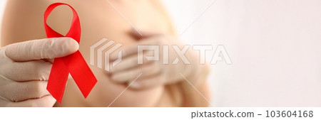 Woman with naked beautiful breasts holds red ribbon 103604168