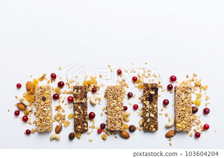 Various granola bars on table background. Cereal granola bars. Superfood breakfast bars with oats, nuts and berries, close up. Superfood concept Various granola bars on table background. Cereal granola bars. Superfood breakfast bars with oats, nuts and berries, close up. Superfood concept 103604204