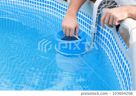 Man cleans skimmer for the frame pool. Contaminated pool cleaning concept 103604206