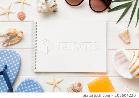 Blank writing book with summer beach accessories on background, copy space. Flat lay with copy space Blank writing book with summer beach accessories on background, copy space. Flat lay with copy space 103604220