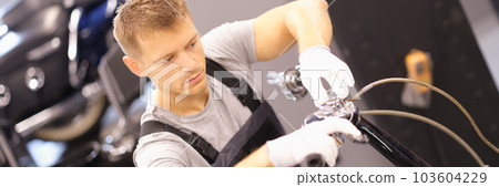 Auto mechanic repairs motorcycle fork in workshop Auto mechanic repairs motorcycle fork in workshop 103604229