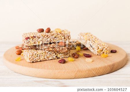 Various granola bars on table background. Cereal granola bars. Superfood breakfast bars with oats, nuts and berries, close up. Superfood concept Various granola bars on table background. Cereal granola bars. Superfood breakfast bars with oats, nuts and berries, close up. Superfood concept 103604527