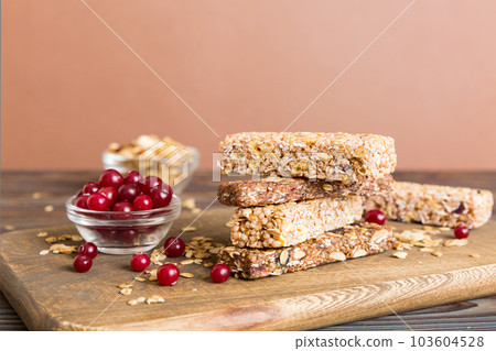 Various granola bars on table background. Cereal granola bars. Superfood breakfast bars with oats, nuts and berries, close up. Superfood concept Various granola bars on table background. Cereal granola bars. Superfood breakfast bars with oats, nuts and berries, close up. Superfood concept 103604528