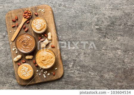Glass jar with peanut butterin plate on table background, top view space for text and close up Glass jar with peanut butterin plate on table background, top view space for text and close up 103604534