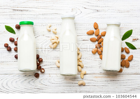 Set or collection of various vegan milk almond, cashew, on table background. Vegan plant based milk and ingredients, top view 103604544
