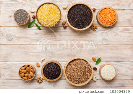 Various superfoods in smal bowl on colored background. Superfood as rice, chia, quinoa, lentils, nuts, sesame seeds, almonds. top view copy space 103604559