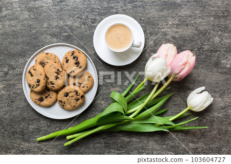 Cup of coffee mug with coffee, cookies and tulips on a colored background. Greeting spring card top view 103604727