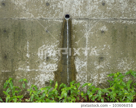 Water flowing down from the drain hole in the retaining wall Front view 103606858