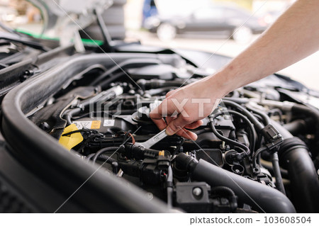 Auto mechanic working in garage. Human hands hold tools. Repair service concept Auto mechanic working in garage. Human hands hold tools. Repair service concept 103608504